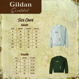 Pu&ograve; includere: Tabella delle taglie per felpe Gildan in taglie per adulti e bambini. La tabella mostra le misure di larghezza, lunghezza e manica in pollici. La tabella &egrave; visualizzata su uno sfondo marrone con una felpa grigia e una felpa verde.