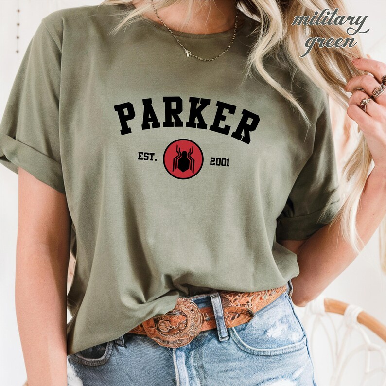 May include: A green t-shirt with the text "PARKER" in black letters in an arch above a red circle with a black spider inside. The text "EST. 2001" is below the circle.