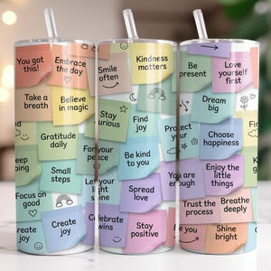 May include: A stainless steel tumbler with a clear straw, covered in colorful sticky notes. Each note has an inspirational message like "You got this!" and "Dream big." The tumbler is a cheerful, motivational accessory.