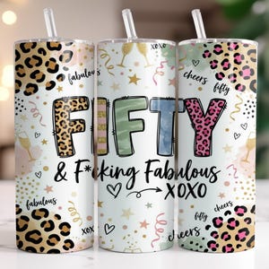 May include: A set of three white insulated tumblers with straws. Each tumbler features a design with the word "FIFTY" in colorful letters, leopard print accents, and the phrase "& F*cking Fabulous". The design includes champagne glasses, stars, and hearts.