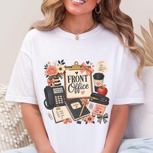 Könnte beinhalten: Ein weißes T-Shirt mit einem Grafikdruck von Bürobedarf, darunter ein Klemmbrett mit dem Text FRONT Office, ein schwarzes Telefon, ein Notizbuch, ein Hefter, ein Kaffeebecher, ein Apfel, Blumen und Haftnotizen mit verschiedenen Texten.