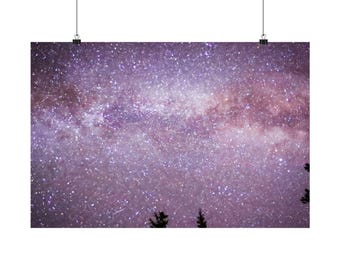 May include: A rectangular wall hanging featuring a vibrant purple and white night sky filled with countless stars and a dense galaxy band, with the dark silhouettes of three pine tree tops visible along the bottom edge.