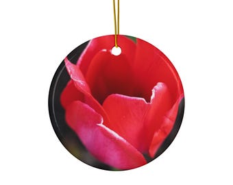 May include: A round ceramic ornament featuring a high-resolution photograph of a vibrant red tulip blossom. The circular decoration includes a small hole at the top with a thin gold string attached for hanging, showcasing deep red petals.