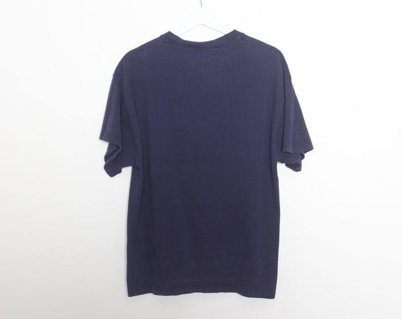 May include: A dark blue t-shirt with short sleeves.