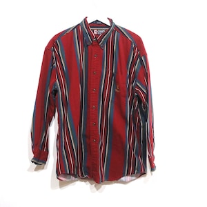 May include: A red, blue, and black striped long-sleeve button-down shirt with the word "CLIPS" on the front.