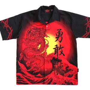 May include: Black short-sleeve button-up shirt with a red dragon design. The shirt features a red and yellow sunset background with Japanese characters. Red vine-like embroidery accents the sleeves.