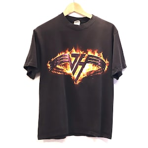 May include: Dark gray t-shirt featuring a flaming logo design. The logo includes the letters "VH" in a stylized font, surrounded by flames. The shirt is hanging on a wooden hanger against a white background.