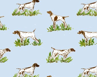 May include: A repeating pattern on a light blue background featuring white and brown spotted hunting dogs standing in patches of green grass. Each dog is depicted in a side profile view, showcasing brown markings on the head and body.