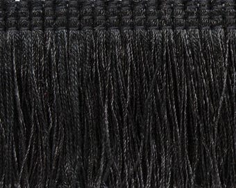 May include: A black fringe trim featuring a woven header with a series of small, rounded loops along the top edge. The trim consists of long, straight, vertical strands of black thread hanging down from the reinforced, textured woven header.