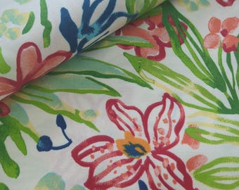 May include: White fabric with a vibrant floral pattern. The design features large red, pink, and orange flowers with yellow centers, along with green and blue leaves. The fabric is folded, showing the pattern's repeat.