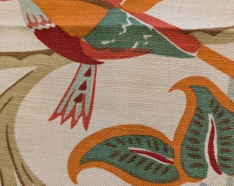 May include: Close-up of a fabric with a repeating pattern of colorful birds and foliage. The birds are orange, red, blue, and green, perched on branches against a cream background. The leaves are green and orange.