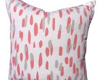 May include: White throw pillow with a pink and gray abstract pattern. The pattern resembles brushstrokes or splatters of paint.