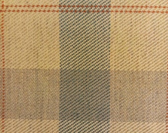 May include: Close-up of a woven fabric with a plaid pattern. The design features a grid of beige, blue, and orange lines. The fabric has a textured appearance, with diagonal lines creating a subtle visual effect. The overall aesthetic is classic and versatile.