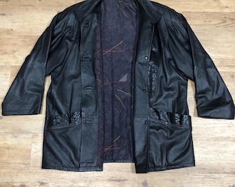 May include: A black leather jacket with a button closure and a patterned lining. The jacket has two pockets on the front and a decorative detail on the bottom.