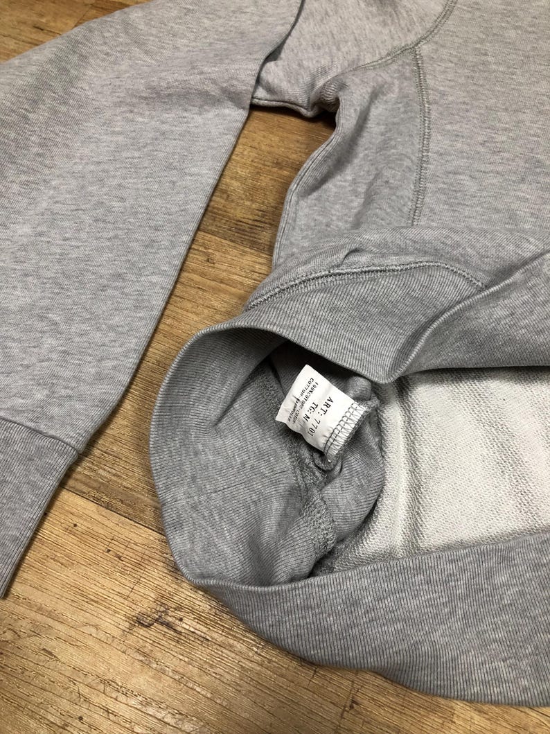 Puede incluir: Una sudadera gris con una etiqueta blanca que dice "ART. N. 7101 TC. M. COTTON 100%"