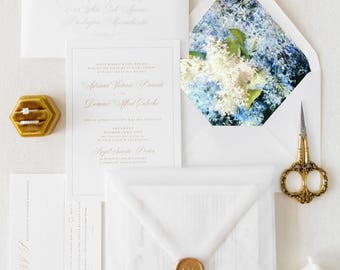 May include: Wedding invitation suite with white envelopes, a wax seal, and a floral design on the inner envelope. The invitation card features the names "Africana Victoria" and "Dominic Alfred" in calligraphy.