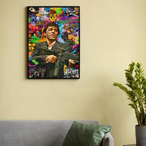 May include: A colorful, abstract painting of a man holding a gun. The painting is framed in black and features graffiti-style text, including "Smile", "Art", and "Happy Graffiti".