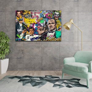 Puede incluir: Una impresi&oacute;n colorida de estilo pop art con un hombre con traje y una corona sobre su cabeza. El fondo est&aacute; lleno de grafitis y texto, incluyendo "Pop Art Legend" y "The World is Yours".