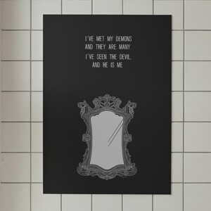 May include: Black poster with the text "I'VE MET MY DEMONS AND THEY ARE MANY I'VE SEEN THE DEVIL, AND HE IS ME" above a decorative mirror illustration. The mirror is gray with an ornate frame.