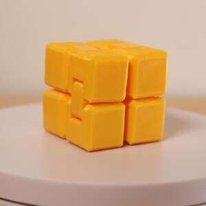 May include: A set of three ceramic mugs with a speckled, matte finish. The mugs are in shades of cream, light gray, and dark gray. Each mug has a simple, minimalist design and a rounded handle.