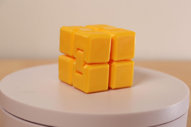 May include: A set of three ceramic mugs with a speckled, matte finish. The mugs are in shades of cream, light gray, and dark gray. Each mug has a simple, minimalist design and a rounded handle.