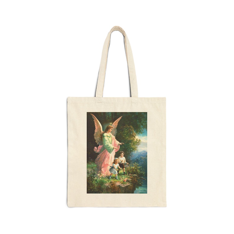 May include: A cream-coloured tote bag displaying a painting of an angel with large wings, leading two children near a river. The angel wears a pink and green gown. The background features trees and a blue sky, creating a serene, pastoral scene.