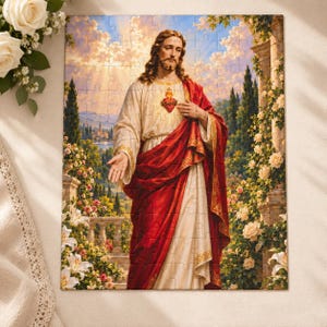 May include: A rectangular jigsaw puzzle featuring a depiction of Jesus Christ with long brown hair and a beard, wearing a cream-coloured robe and a deep red cloak. A glowing Sacred Heart emblem is visible on the chest. The background shows a garden.