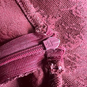 May include: Close-up of a maroon zipper with a plastic zipper pull. The zipper pull has the number "400" printed on it.