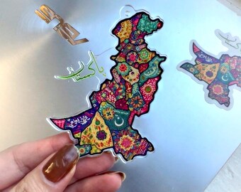 May include: A colourful sticker of Pakistan with intricate patterns and designs. The sticker is on a silver laptop with other stickers, including a red tiger and a blue and white sticker that says "Follow Your Heart" with a sun and waves.