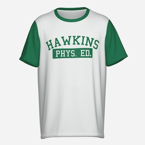 Puede incluir: Camiseta de malla blanca con mangas y cuello verdes. La parte delantera de la camiseta presenta el texto "HAWKINS PHYS. ED." en letras verdes. La camiseta tiene un estilo atlético clásico.