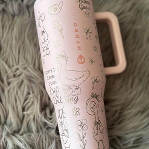 May include: A pink HydroJug water bottle with a handle, featuring a Mama Goose design. The bottle is adorned with illustrations of geese, bows, flowers, and the text "Sorry I'm Late... I was Dilly Dallying."
