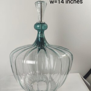 May include: Clear glass pendant light with teal accents and a ribbed design. The light fixture has a width of 14 inches and a decorative top. The text "custom order" is visible.