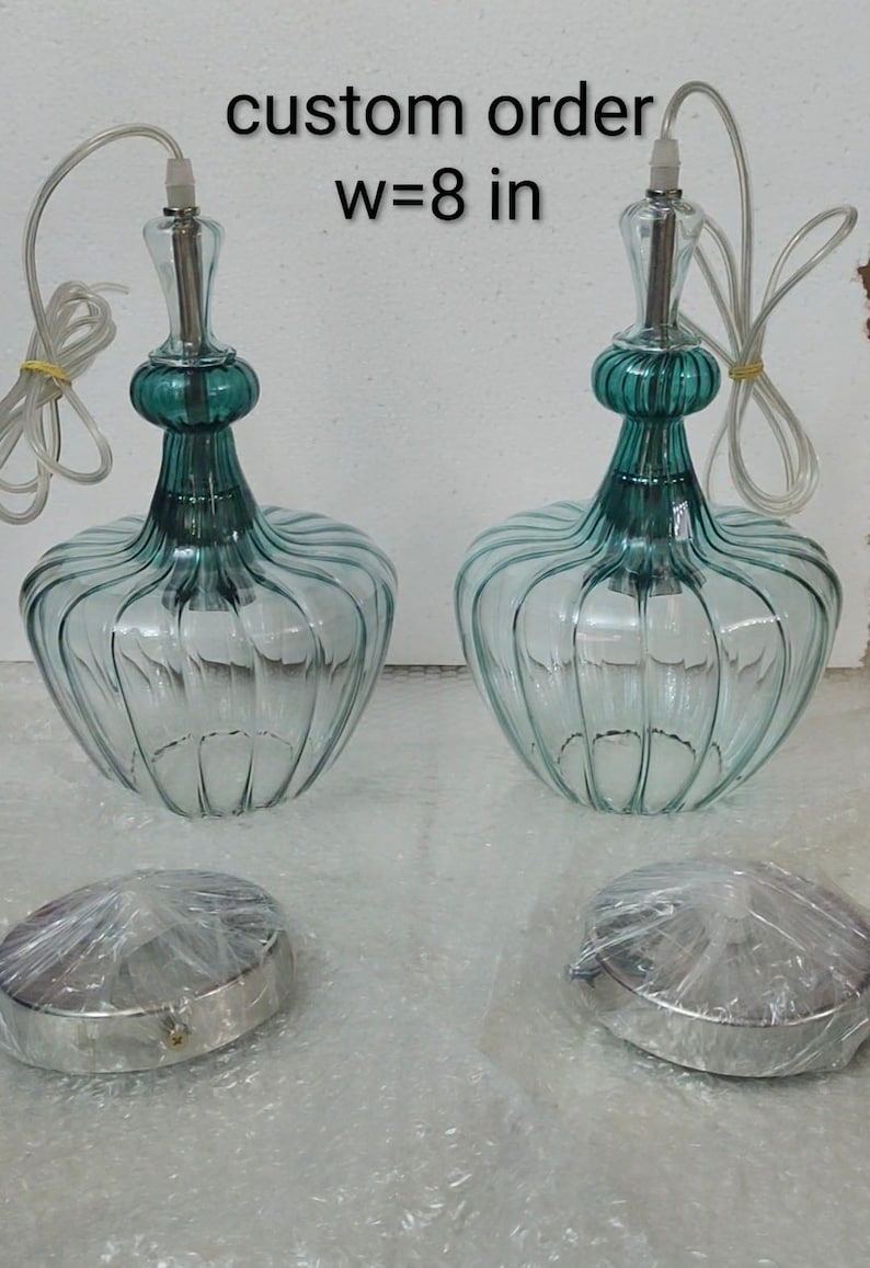 May include: Two clear glass pendant lights with teal accents and a ribbed design. Each light is approximately 8 inches (20 cm) wide. The text "custom order w=8 in" is visible in the image.