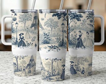 May include: Three stainless steel travel mugs with white handles and lids. Each mug features a blue and white toile design with scenes of the Eiffel Tower, trees, and figures in period clothing. The mugs include silver straws.