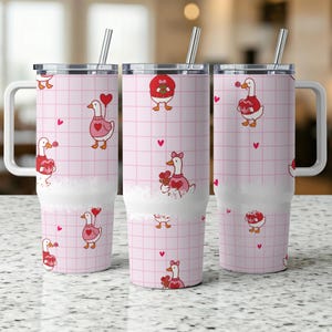 May include: Three stainless steel tumblers with white handles and lids. The tumblers feature a pink grid pattern with cartoon geese holding hearts and flowers. Each tumbler includes a silver straw.