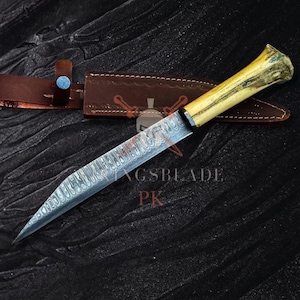 Puede incluir: Un cuchillo artesanal con una hoja estampada y un mango de color claro. El cuchillo se muestra con una funda de cuero marrón. El texto "GSBLADE PK" es visible en la hoja. El cuchillo está diseñado para cortar.