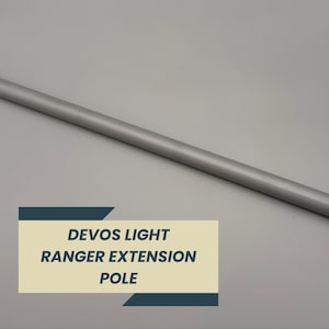 May include: A silver-colored DEVO'S LIGHT RANGER EXTENSION POLE. The pole is cylindrical and appears to be made of metal. The text "DEVOS LIGHT RANGER EXTENSION POLE" is displayed on a rectangular label in the lower left corner.