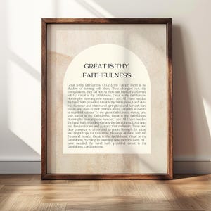 Könnte beinhalten: Ein gerahmter Wandkunstdruck mit einem dunkelbraunen Holzrahmen und einem cremefarbenen Hintergrund. In der Mitte befindet sich eine Bogenform mit dem Text Great Is Thy Faithfulness, gefolgt vom vollständigen Liedtext in schwarzer Serifenschrift.