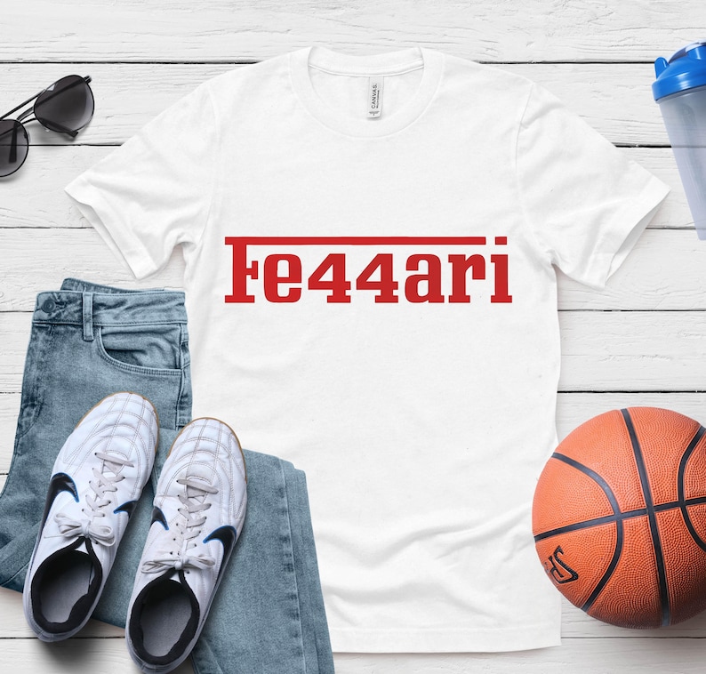 May include: White t-shirt with the red text "Fe44ari" above a red line. The shirt is next to blue jeans, white sneakers, a basketball, sunglasses, and a blue water bottle.