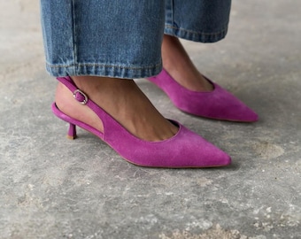 Décolleté basse in camoscio fucsia con cinturino posteriore, punta affusolata e tacco a spillo, cinturino regolabile sul retro.