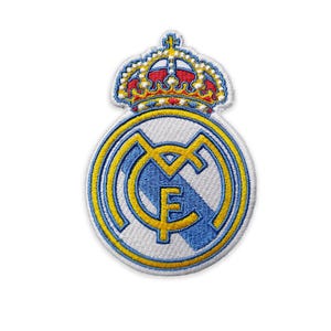 Può includere: Toppa ricamata con lo stemma del Real Madrid. La toppa ha uno sfondo bianco con un emblema circolare blu e giallo. Una corona dorata con dettagli rossi e blu sovrasta l'emblema. Progettata per l'applicazione su abbigliamento o accessori.