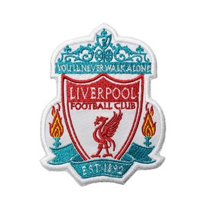 Może przedstawiać: Haftowana naszywka z herbem Liverpool Football Club. Herb jest czerwono-biały, z czerwonym ptakiem i napisem "LIVERPOOL FOOTBALL CLUB". Naszywka zawiera tekst "YOU'LL NEVER WALK ALONE" i "EST 1892" w kolorze morskim.