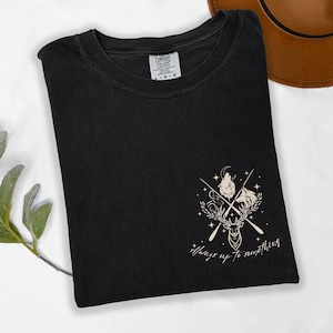 May include: Black t-shirt with a graphic design featuring a wolf, deer, and horse with crossed arrows and the text "Always up to something." The shirt is from Comfort Colors.