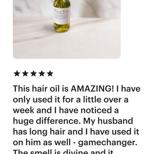 May include: A glass bottle of hair oil with a gold dropper and a white label that reads "Every Body Hair Oil". The bottle is sitting on a white marble surface.