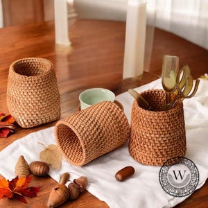 Peut inclure: Trois paniers en osier tressé de formes et de tailles différentes. Les paniers sont en rotin brun naturel et sont parfaits pour organiser de petits objets.