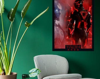 May include: A framed poster with a Tron: Ares design. The poster features two figures in a red and blue color scheme. The text "TRON ARES" is at the bottom of the poster.