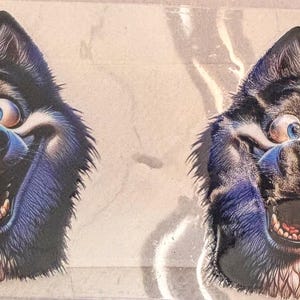 May include: Two identical stickers featuring a cartoon-style Siberian Husky dog head with black and white fur, large expressive blue eyes, a wide grin, and a bright red tongue hanging out. The illustration has a bold, high-contrast aesthetic.