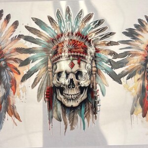 May include: A set of three graphic transfers featuring human skulls wearing elaborate feathered headdresses. The left skull has orange and blue feathers, the center skull has teal and red accents, and the right skull features brown and cream tones.