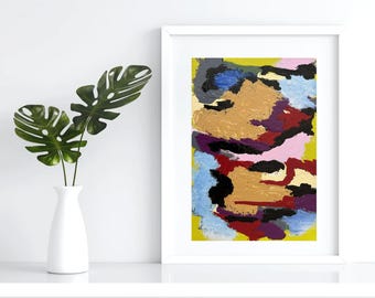 Könnte beinhalten: Abstrakter Kunstdruck in einem weißen Rahmen. Das Kunstwerk zeigt ein strukturiertes, farbenfrohes Design mit Gold-, Rot-, Lila-, Schwarz-, Blau- und Rosatönen auf gelbem Hintergrund. Eine weiße Vase mit grünen Blättern befindet sich im Vordergrund.