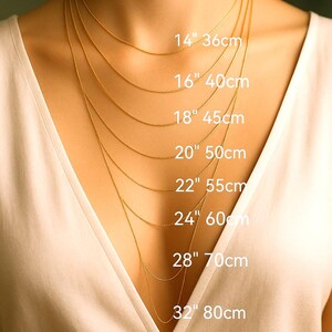 a close-up of a person's neck with multiple gold necklaces of varying lengths, each labeled with its corresponding size in centimeters.